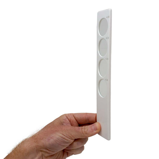 A hand holding a white Confirmation Bar with +0.50, +0.25, -0.25 and -0.50 glass lenses for convenient optometric testing.