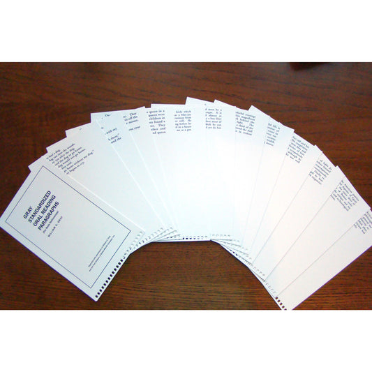 White paper pages with black printed text, arranged on a dark brown wooden surface.