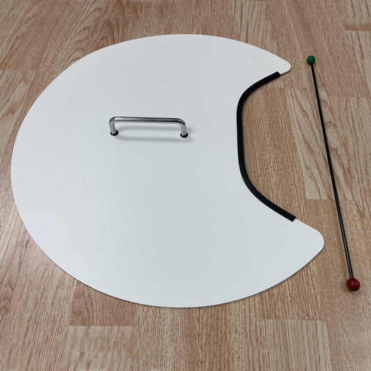 Bottom of the Bernell Vision Disc showing the chrome handle and a fixation wand with red and green ends, shown on a light wood surface.