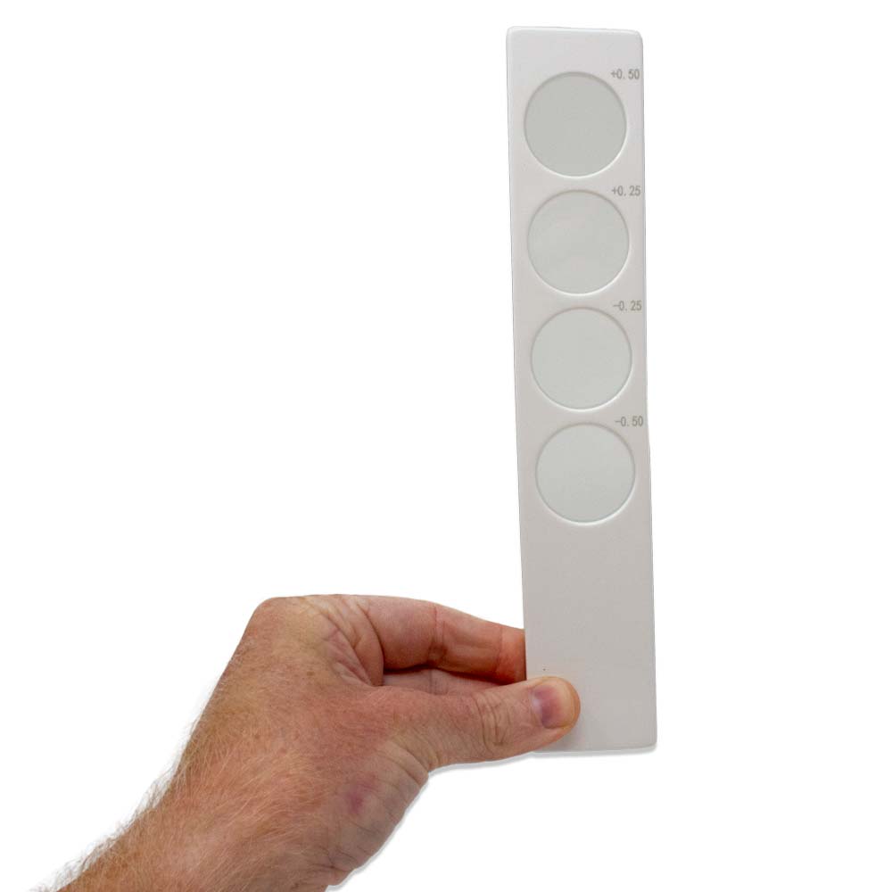 A hand holding a white Confirmation Bar with the glass lens strengths printed on the side.