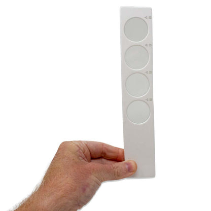 A hand holding a white Confirmation Bar with the glass lens strengths printed on the side.