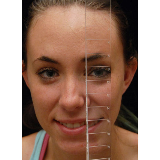 Close-up of a woman's face with a transparent vertical measuring ruler overlaid, showing facial features and a measurement scale from 1 to 20.