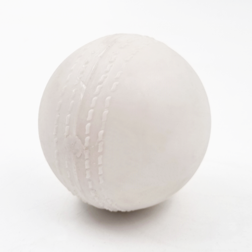 A white plastic cricket ball with stitched seam details, photographed on a seamless white background.